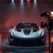 Un créateur automobile premium filme une supercar dans un studio haut de gamme avec caméra, micro et éclairage professionnel, mettant en valeur les reflets et la carrosserie.