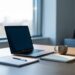 Bureau professionnel avec ordinateur portable ouvert et carnet, lumiere naturelle du matin