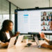 Une équipe de PME composée de deux femmes et deux hommes collabore autour d’ordinateurs et d’un grand écran dans un bureau moderne, avec des interfaces numériques abstraites et une visioconférence.