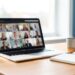 Bureau à domicile avec ordinateur portable ouvert sur une visioconférence d'équipe